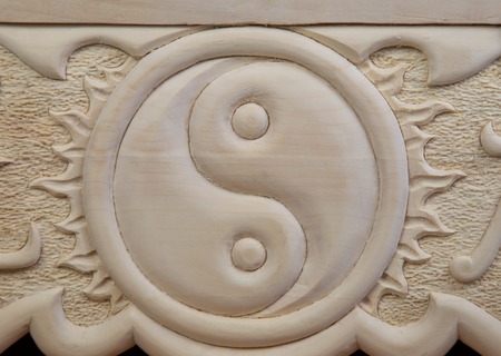 yin yang carved out of wood close upの写真素材
