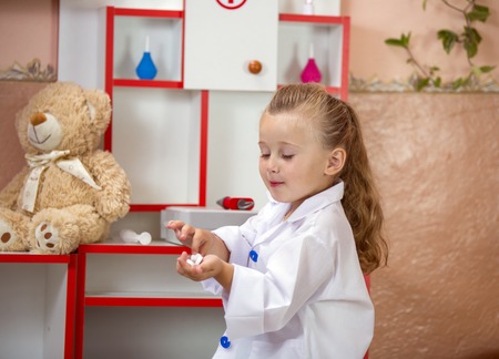 child's doctor examines a teddy bearの写真素材