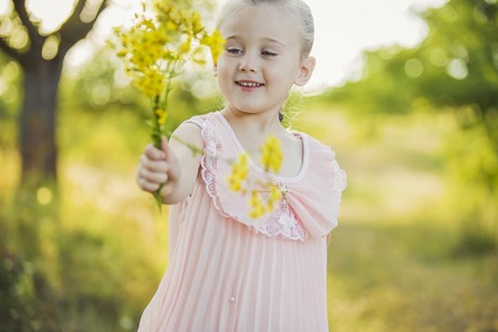 Girl with yellow flowers in a parkの写真素材