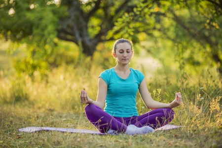 woman in lotus pose on the natureの写真素材