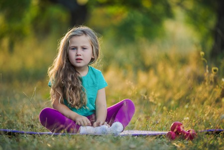 little girl sitting on a natureの写真素材