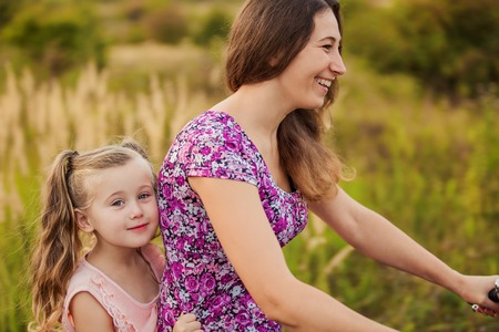 mother with her baby and a bike ride in natureの写真素材