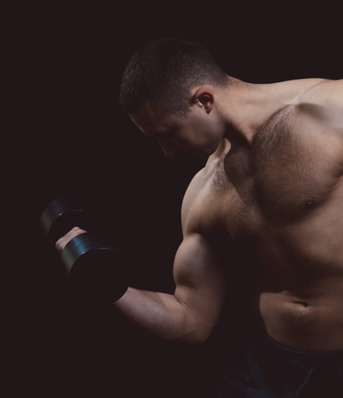 man with a dumbbell on a black backgroundの写真素材
