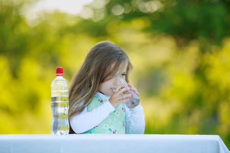 Little girl drinking water outdoorsの写真素材