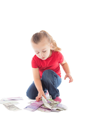little girl with a bunch of money on a white backgroundの写真素材