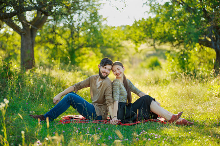 Happy couple sitting in natureの写真素材