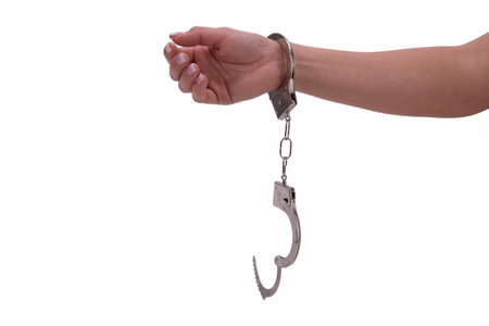 woman's hand with handcuffs on white backgroundの写真素材
