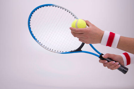Woman hands with tennis racket on a white backgroundの写真素材