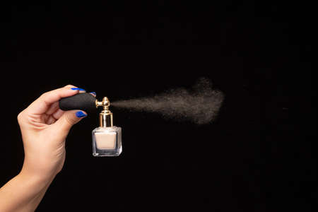 Perfume spray with a glass bottle on black background