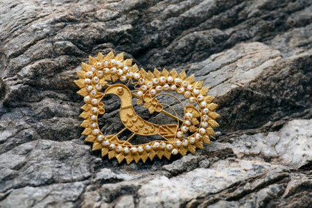 Sardinian gold filigree brooch with a bird depicted on a rockの写真素材