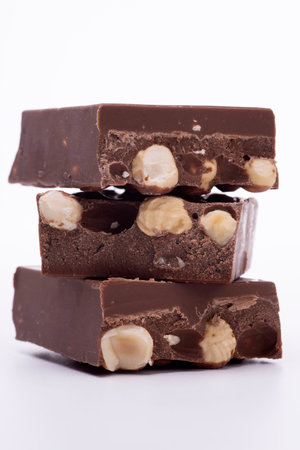 chocolate squares with hazelnuts on a white backgroundの写真素材