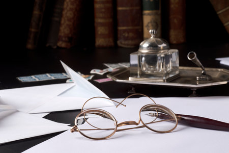 The work of a writer with pen and inkwell and sheets of paper, reading glasses, booksの写真素材