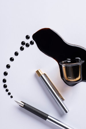 Pencils and a bottle of black paint on a white backgroundの写真素材