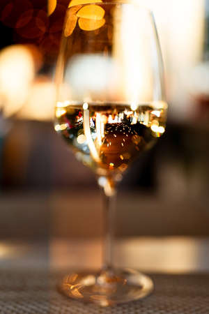 Glass of white wine full with bokeh lights