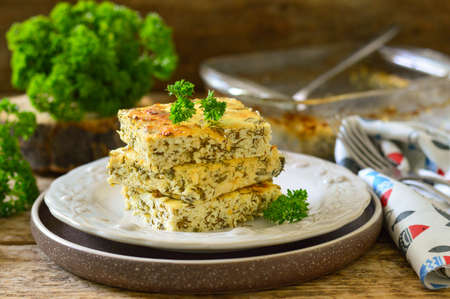 Zucchini casserole with cheese and parsley on a wooden backgroundの写真素材