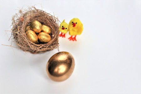 Golden Easter eggs and chickens with copy space for text on a white background