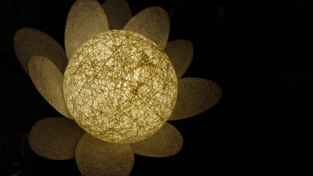 Bright glowing white round lamp flower on black backgroundの写真素材