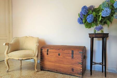 old wooden chest, antique armchair, vase with blue hydrangea flowersの写真素材