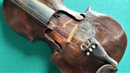 Old violin in vintage style on green backgroundFragment of a violin close-up, a musical instrument on a green backgroundの写真素材