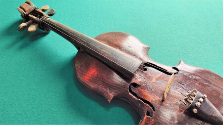 Old violin in vintage style on green background
Fragment of a violin close-up, a musical instrument on a green backgroundの写真素材