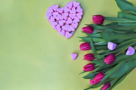Valentine's day concept. bouquet of flowers, pink tulips. Marshmallow hearts. 
Yellow backgroundの写真素材