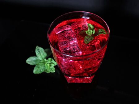 Fresh red cocktail with ice cubes and mint leaves. Red summer berries . Tasty juicy drink.の写真素材