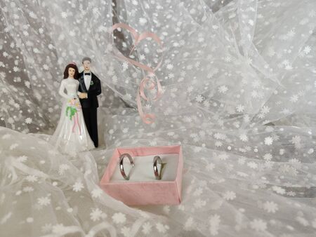wedding concept. newlywed figurine, wedding  rings  on the background of a white veil. Copy spaceの写真素材