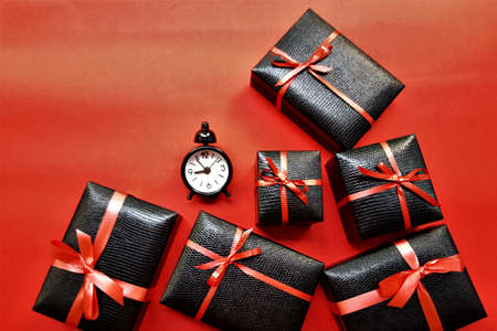 Black friday concept on a red background. Black gift boxes and watches on a red backgroundの写真素材