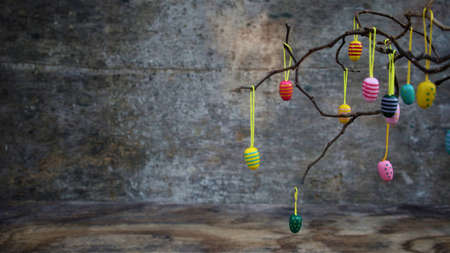 Easter dekorative eggs on tree branches. Easter tree in vase with colorful eggs on a gray rustic...