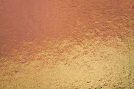 Metallic gold color, shiny reflective textured background
