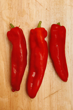 sweet red peppers on wooden chopping boardCapsicum