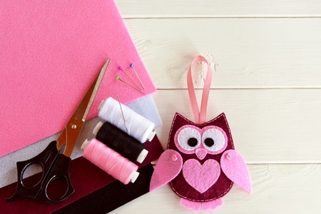 Handmade felt owl. Nice children's toy. Felt sheets, scissors, thread, needles, pins - sewing kitの写真素材
