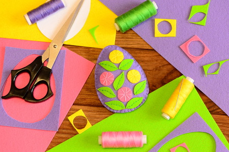 Bright Easter egg made of felt and decorated with flowers. Colorful felt crafts for Easter. Sewing...