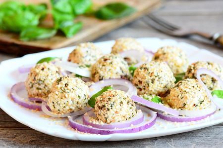 Cheese balls on a plate. Cheese balls with spices and roasted sesame seeds served with raw onion...