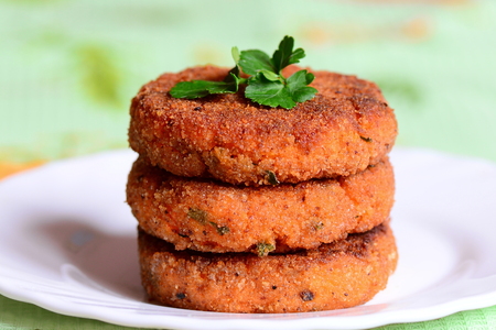 Veggie carrot cutlets on a plate. Tasty fried carrot cutlets with green onions and parsley. Healthy...