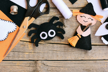 Quick Halloween crafts. Felt witch doll, spider decorations on a vintage wooden background. Needlework tools and materials. Easy felt Halloween crafts for preschoolers. Top viewの写真素材