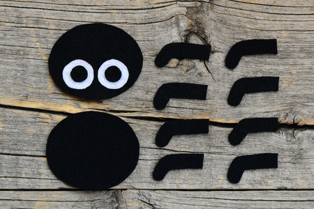 Creating a felt Halloween spider ornament. Step. Cut out the Halloween spider toy. Felt projects for beginners and kids. Old wooden background. Top view. Closeupの写真素材