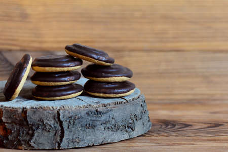 Cookie stack on a wooden background. Round biscuits in chocolate glaze. Closeup. Chocolate cookie photo. Chocolate biscuits. Chocolate cookie. Dessert. Cookies with chocolate icingの写真素材