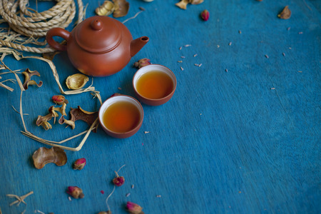 teapot with two cups on blue wooden table, focus on the teapot.の写真素材