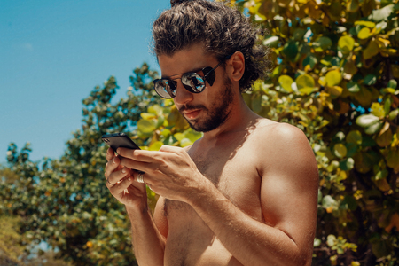 handsome young man with cell phone outdoorsの写真素材