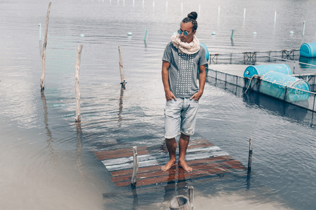 Handsome young man in denim shorts outdoorsの写真素材