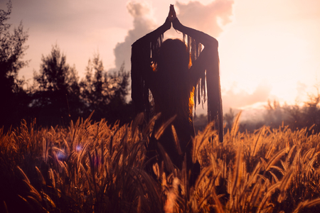 beautiful woman silhouette on sunsetの写真素材