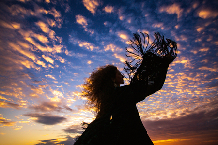 woman silhouette  sunset sky  sleeves flight fringeの写真素材