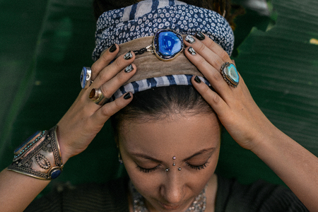 close up of woman hands with boho gem stones rings