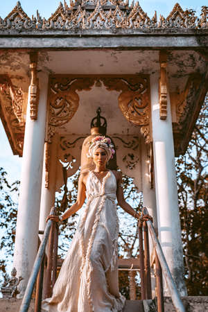 beautiful young stylish woman wearing flowers wreath outdoors at sunsetの写真素材
