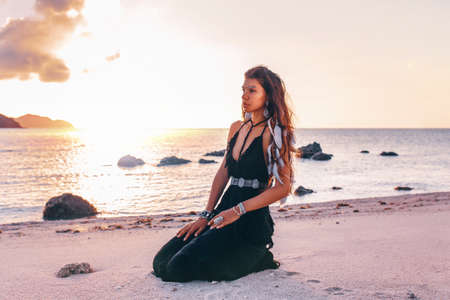 beautiful young fashionable woman on the beach at sunset