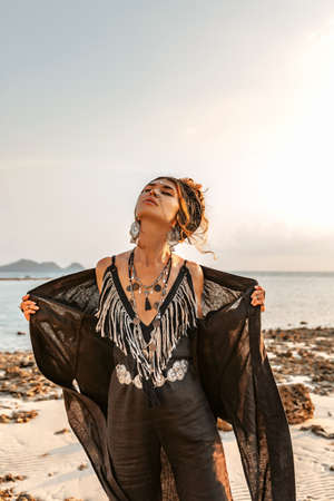 beautiful young stylish woman posing at sunset
