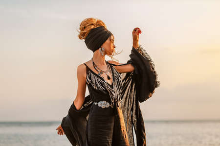 beautiful young stylish woman posing at sunsetの写真素材