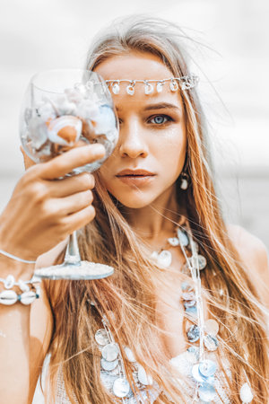 beautiful young stylish woman close up portrait with glass full of sea shells