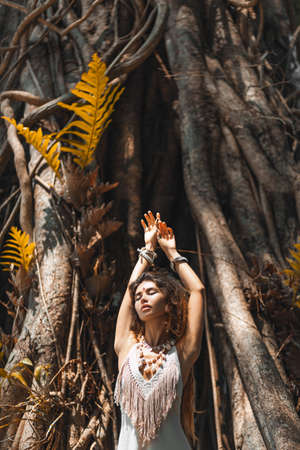 Beautiful young woman in elegant dress at nature backgroundの写真素材